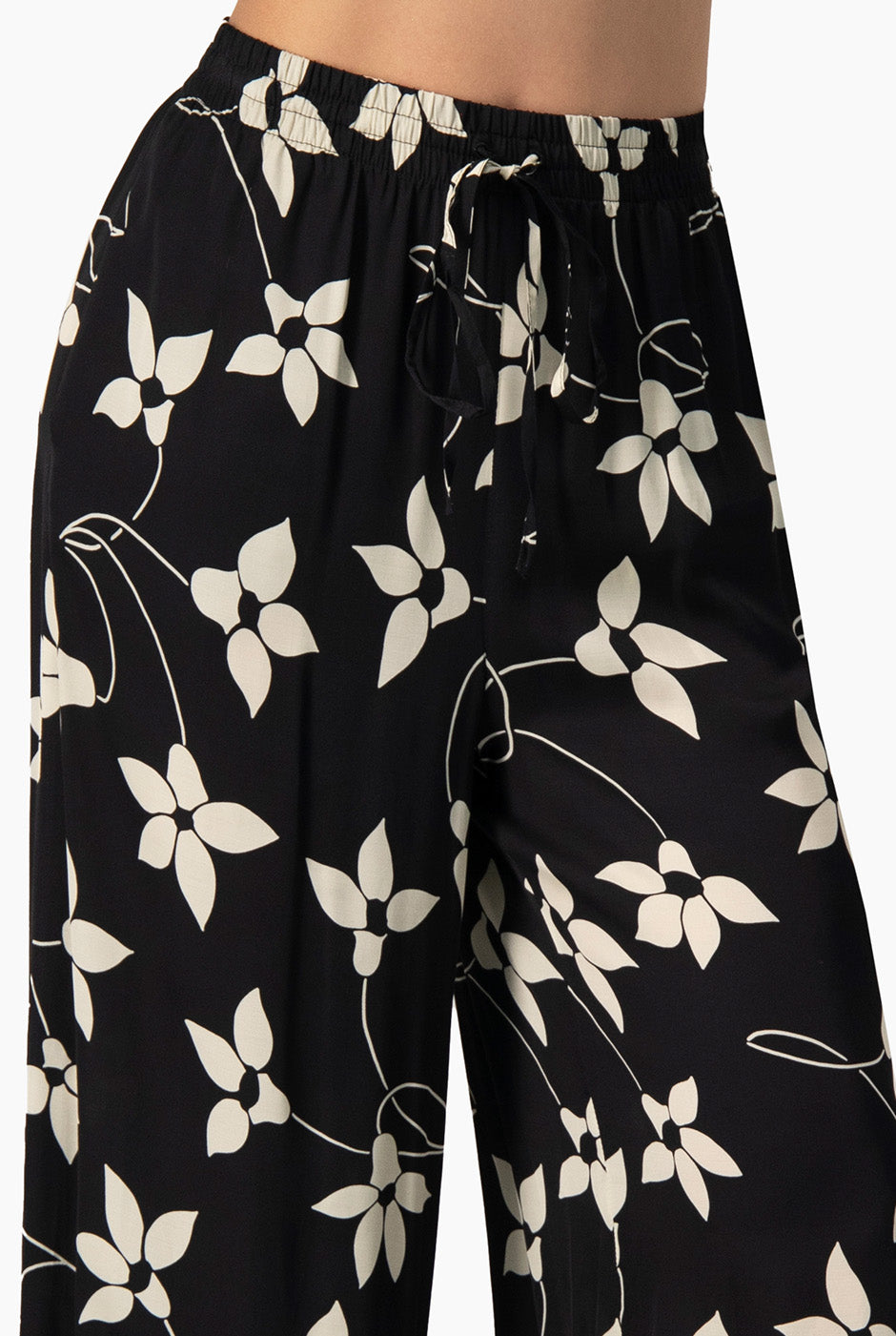 Pantalón amplio negro con estampado floral y bolsillos